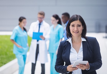 Staff member holds tablet with clinicians behind at US Heart and vascular