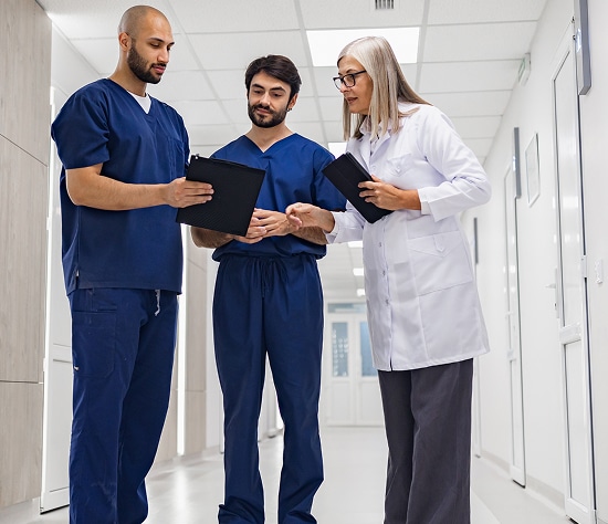 US Heart and Vascular staff review clipboard in corridor at hospital