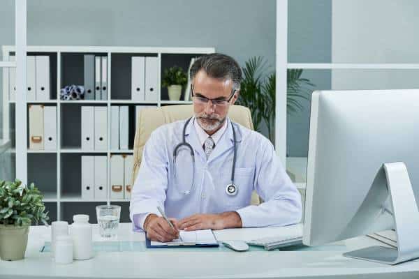 Cardiologist reviews paperwork at office desk at US Heart and vascular