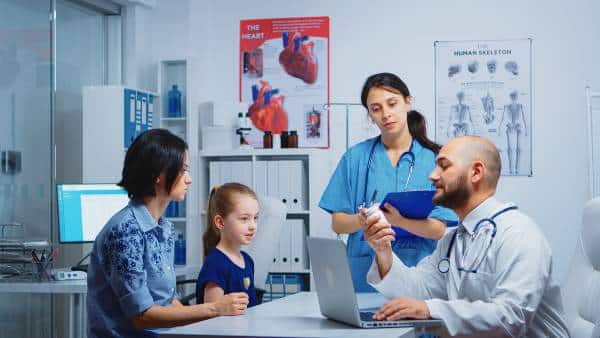 Doctor consult with patient beside medical monitor at US Heart and vascular