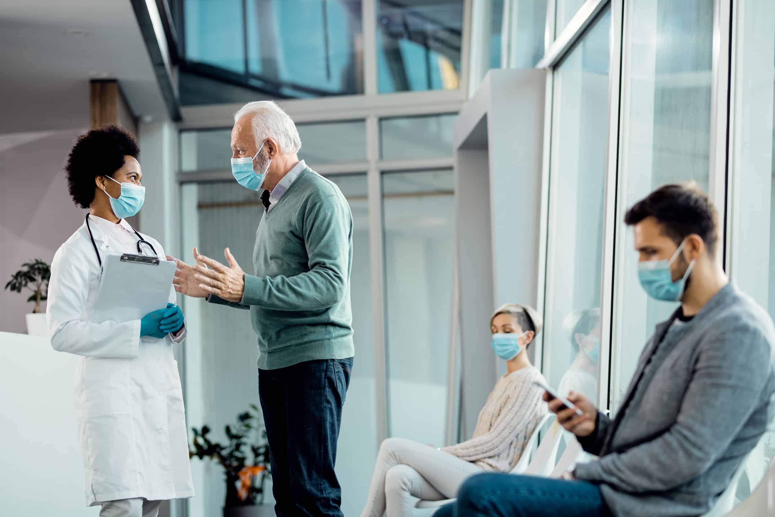People outside the hospital room wearing masks